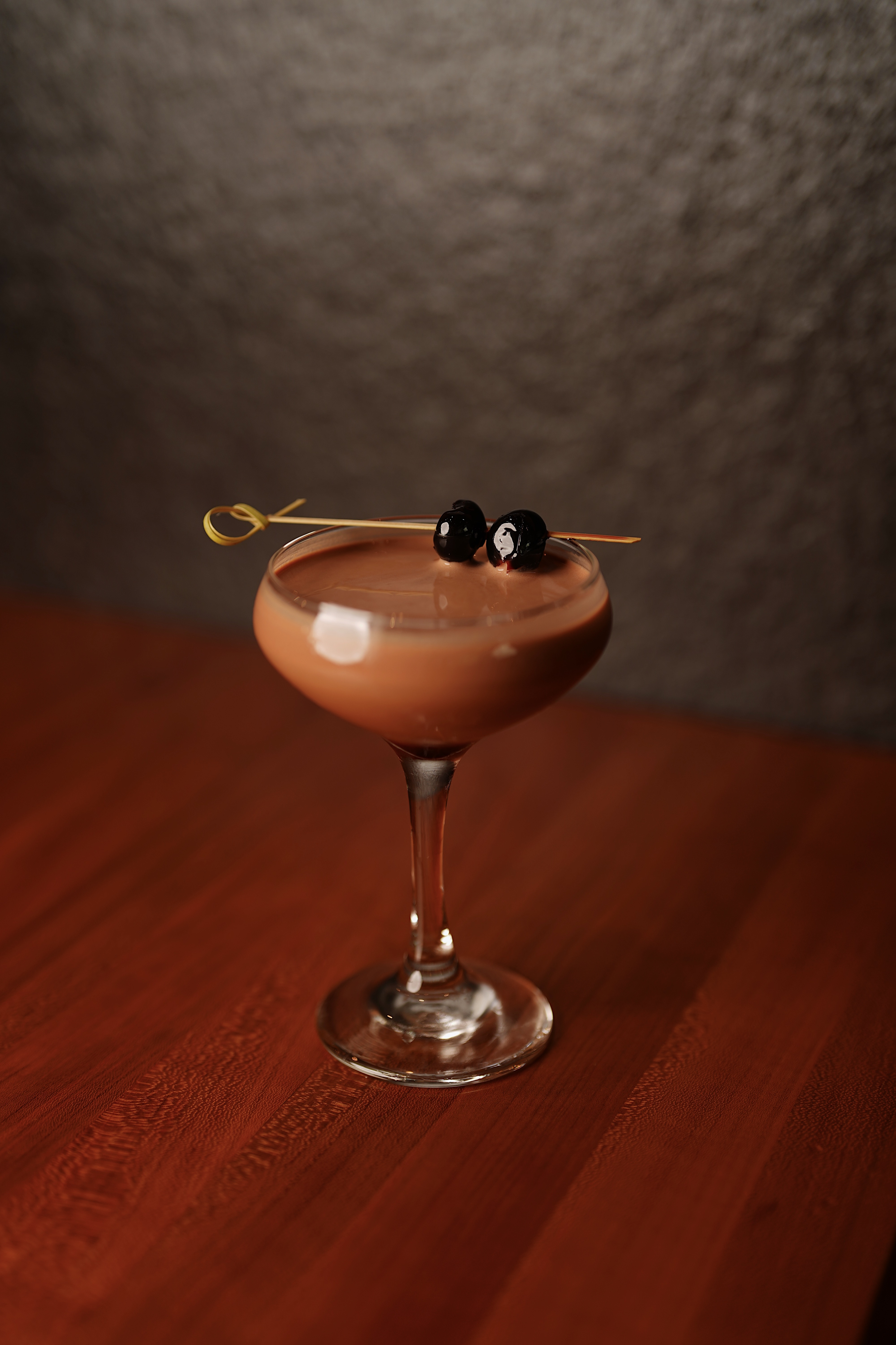 Signature coupe cocktail with Luxardo cherries